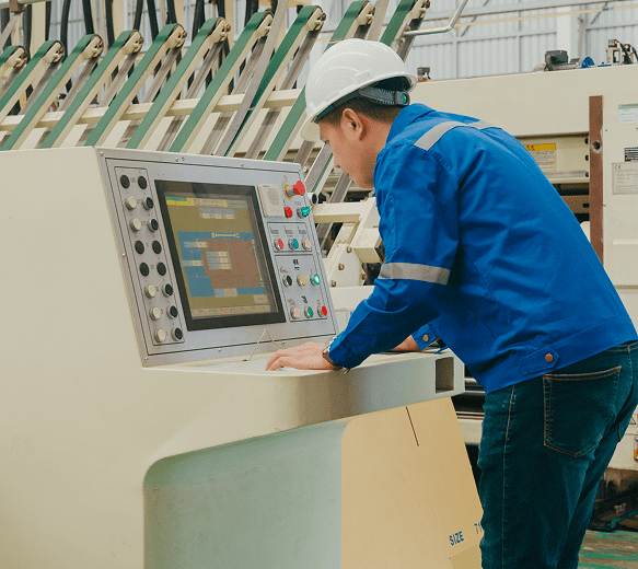 Worker operating industrial machine control panel